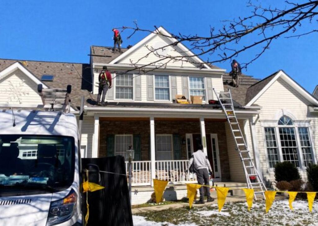 contractors working on the roof of home during winter