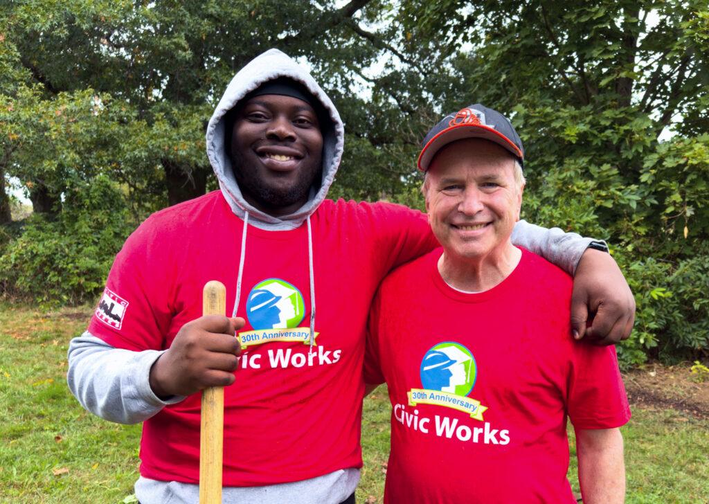 2 volunteers on Ricky Myers day wearing red Civic Works anniversary shirts