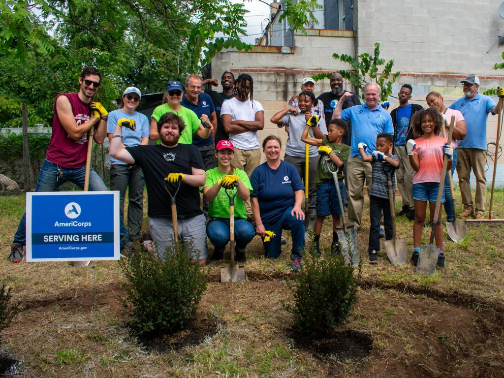 group of AmeriCorps members posing for a photo in a outdoor space they are landscaping