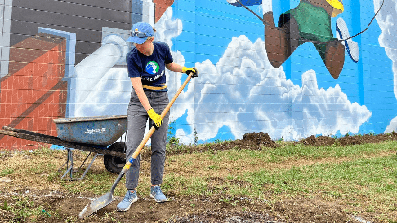 civic works member working using a shovel landscaping a city alley