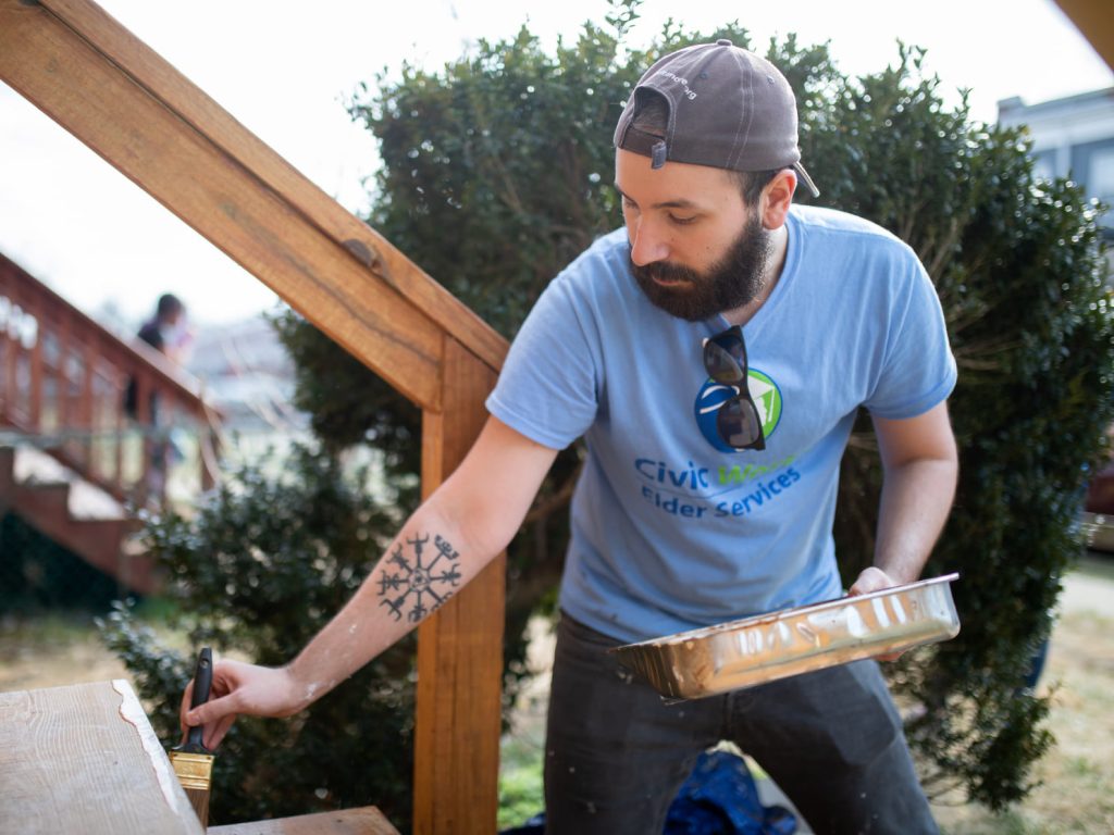 volunteer painting front steps of a house