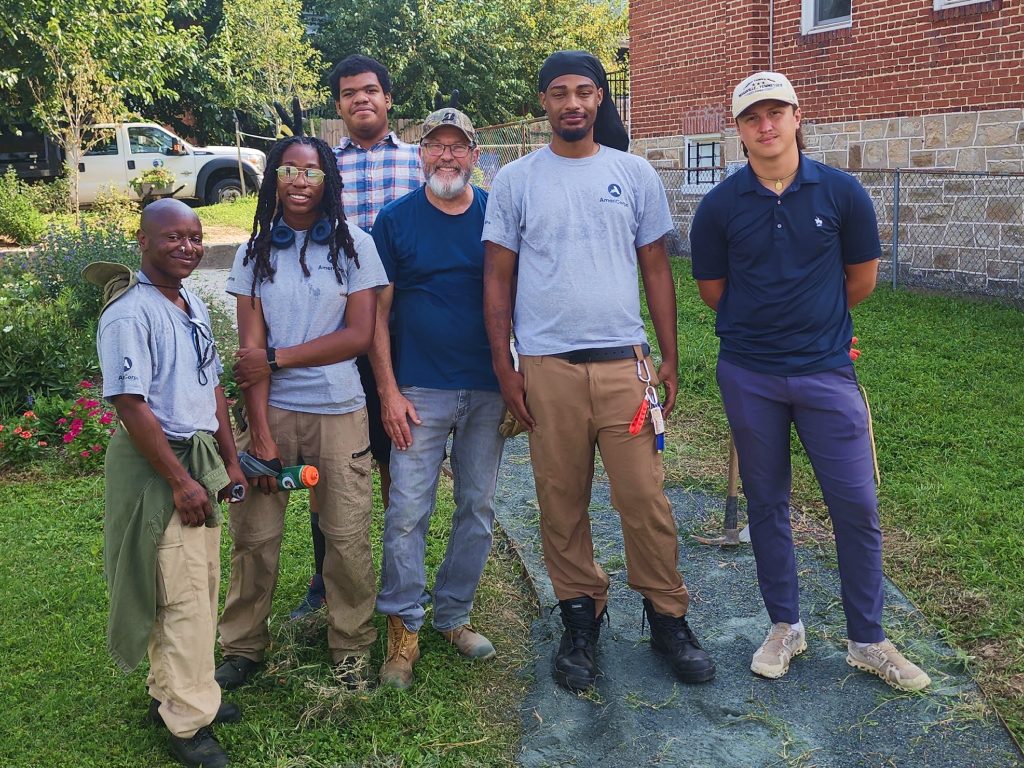 Group of volunteers posing for a photo in a alley they landscaping